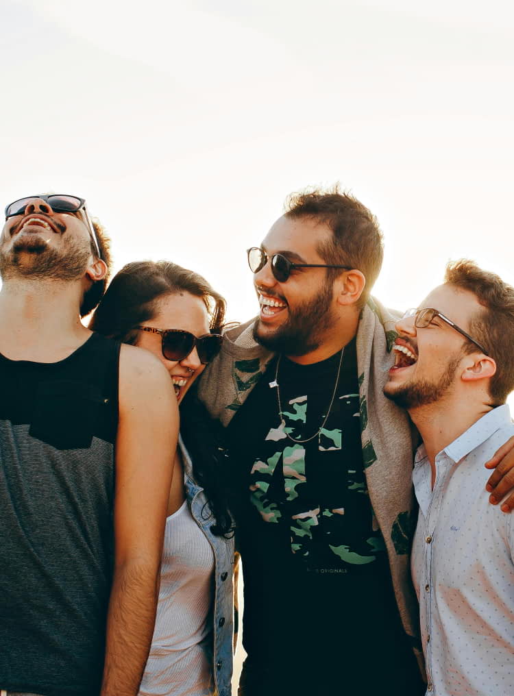 Grupo de quatro amigos gargalhando juntos